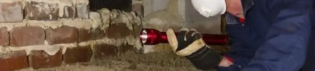 Pest control technician inspecting a crawl space for ant activity and entry points in Columbia, MO